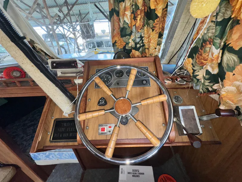 Slide: The Image of 1974 Roberts 30' boat helm with wooden wheel and floral curtains in cabin. - 21