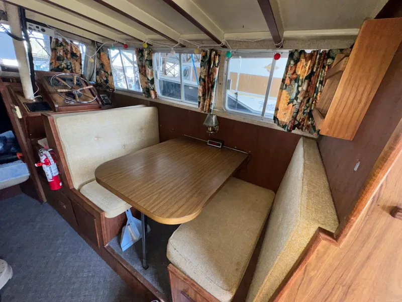 Slide: The Image of 1974 Roberts 30' boat interior with dining area, wooden table, and floral curtains. - 22