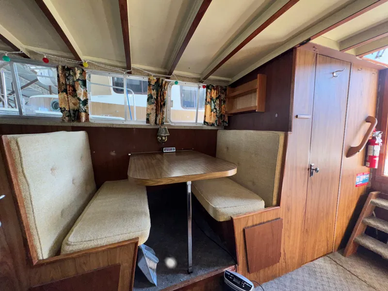 Slide: The Image of 1974 Roberts 30' boat interior with cozy dining area and floral curtains. - 23