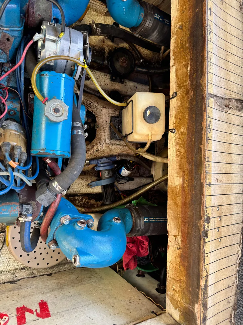 Slide: The Image of Engine compartment of a 1974 Roberts 30' boat, featuring blue components and hoses. - 28