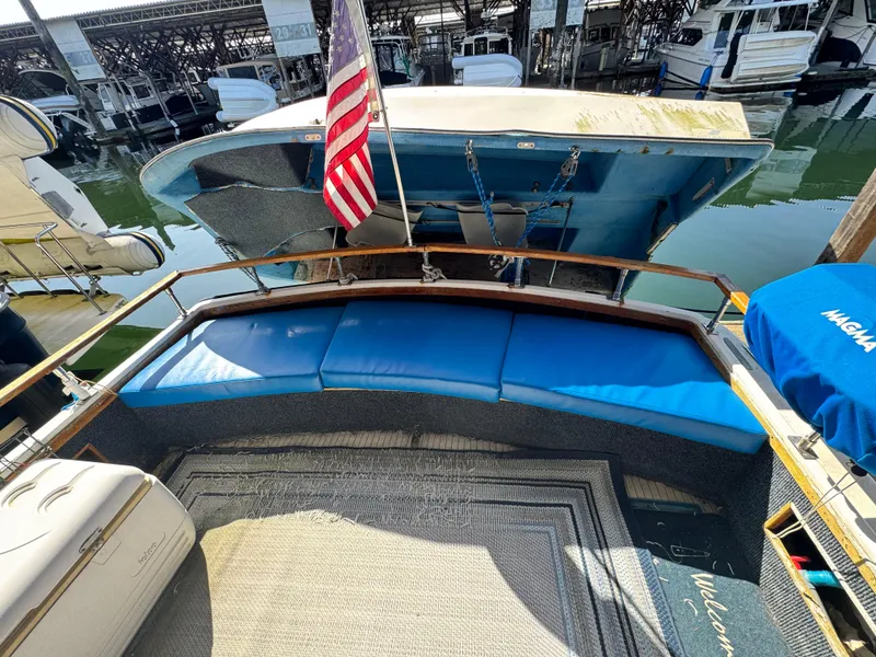 Slide: The Image of 1974 Roberts 30' boat with blue seating and American flag at marina. - 3