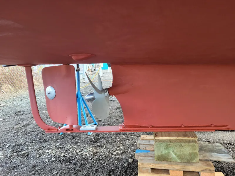 Slide: The Image of Close-up of a 1974 Roberts 32 boat's propeller and rudder, supported on wooden blocks. - 33