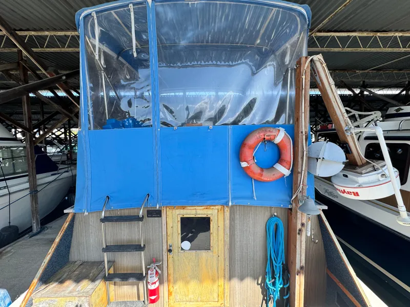 Slide: The Image of 1974 Roberts 30' boat with blue canopy and life preserver in a covered dock. - 5