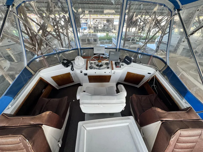 Slide: The Image of 1974 Roberts 30' boat cockpit with steering wheel, navigation equipment, and seating under a canopy. - 6