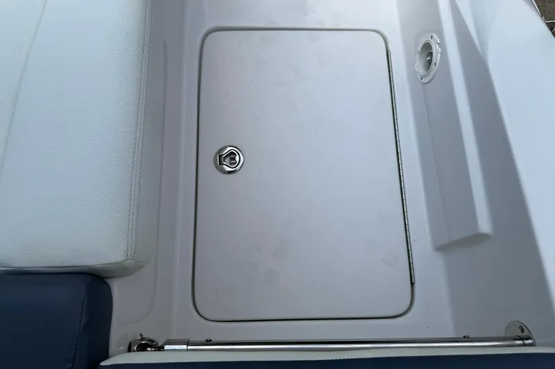 Slide: The Image of 2009 Four Winns SL222 boat storage compartment with white cushioned seating. - 19