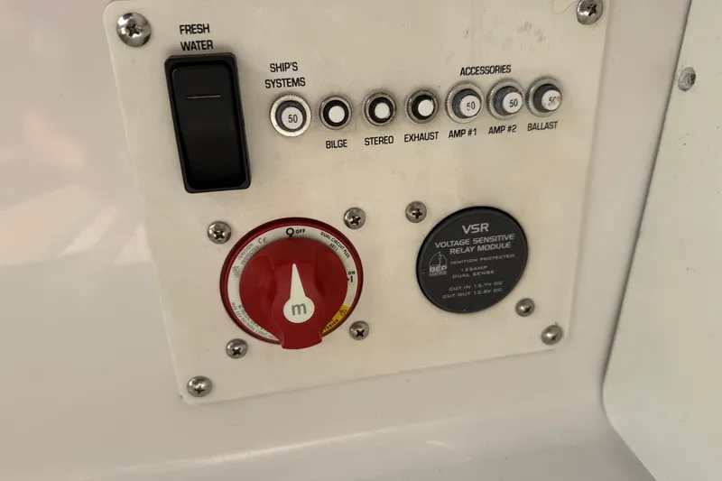 Slide: The Image of Control panel of a 2009 Four Winns SL222 boat with switches and voltage module. - 22