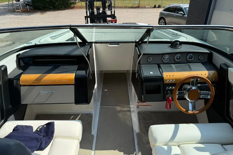 Slide: The Image of 2009 Four Winns SL222 boat interior with steering wheel, dashboard, and seating. - 24
