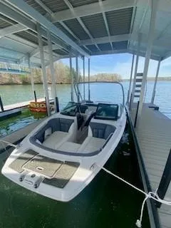 Slide: The Image of 2009 Four Winns SL222 boat docked under a covered marina on a sunny day. - 3