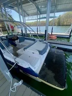 Slide: The Image of 2009 Four Winns SL222 boat docked on a serene lake under a covered slip. - 4