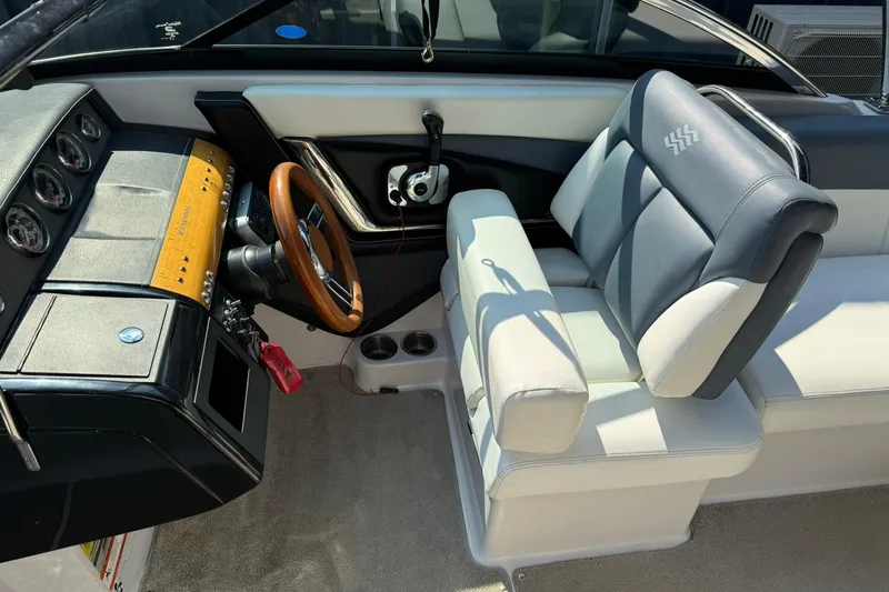 Slide: The Image of 2009 Four Winns SL222 boat interior with steering wheel and dashboard controls. - 6