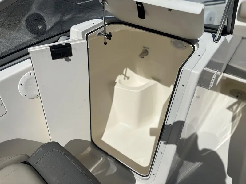 Slide: The Image of 2025 Key West 203 DFS boat storage compartment, open door, white interior, modern design. - 14