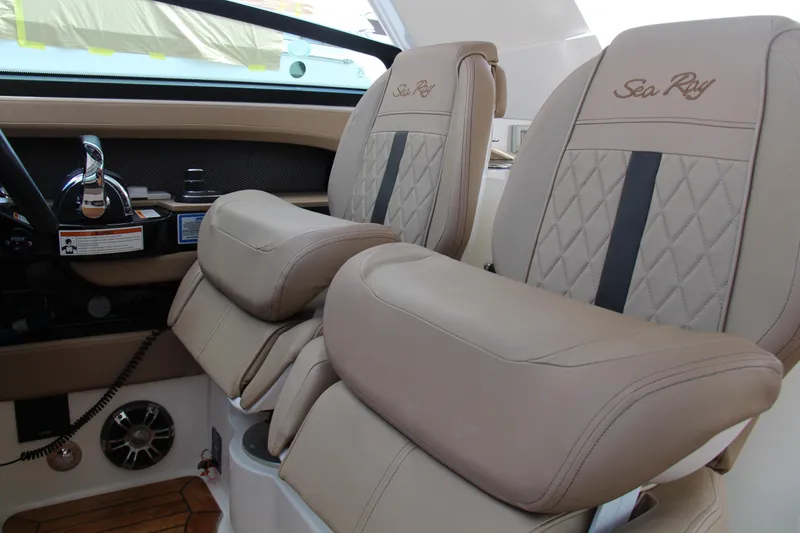 Slide: The Image of 2019 Sea Ray SLX 400 helm seats with luxurious beige upholstery and embroidered branding. - 16