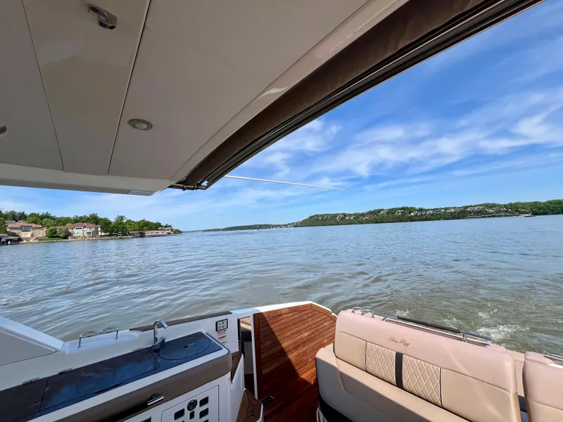Slide: The Image of 2019 Sea Ray SLX 400 boat with open deck, overlooking serene lake and blue sky. - 17