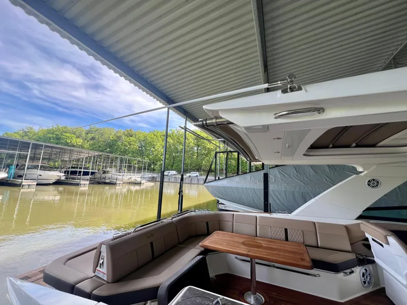 Slide: The Image of 2019 Sea Ray SLX 400 yacht interior with seating and table, docked under a covered marina. - 19