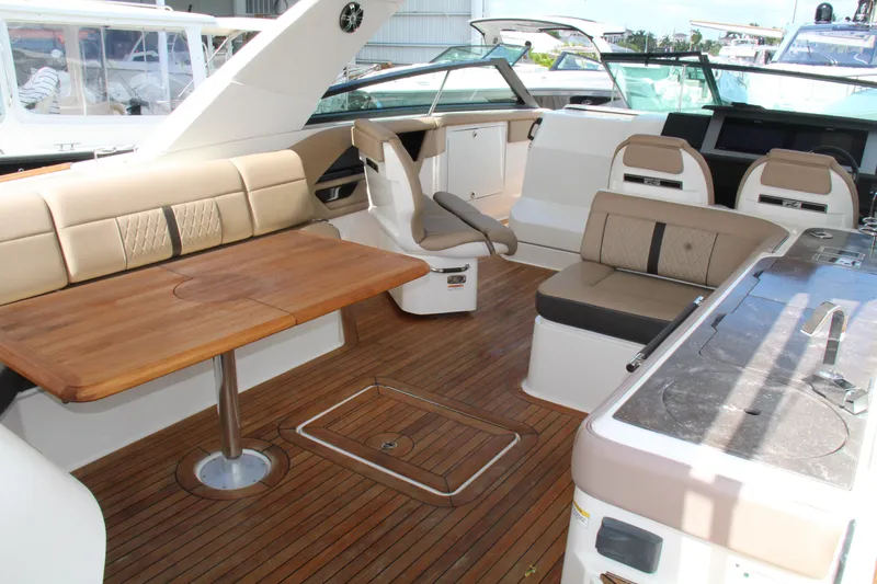 Slide: The Image of 2019 Sea Ray SLX 400 interior with wooden deck, seating, and table. - 21
