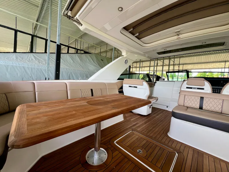 Slide: The Image of 2019 Sea Ray SLX 400 interior with elegant seating and wooden table. - 22