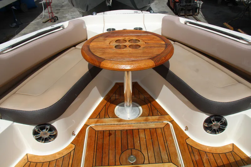 Slide: The Image of 2019 Sea Ray SLX 400 boat interior with wooden table and cushioned seating. - 26