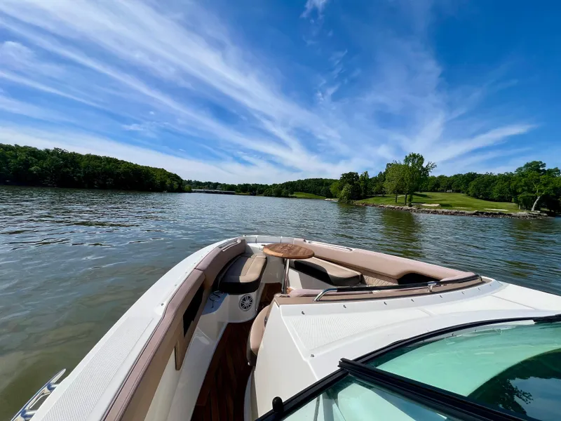 Slide: The Image of 2019 Sea Ray SLX 400 cruising on a serene lake under a clear blue sky. - 28