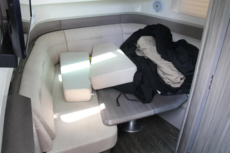 Slide: The Image of 2019 Sea Ray SLX 400 interior with beige seating and cushions, showcasing a cozy cabin area. - 34