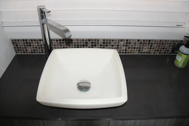 Slide: The Image of Modern square sink with chrome faucet on dark countertop, Sea Ray SLX 400, 2019. - 36