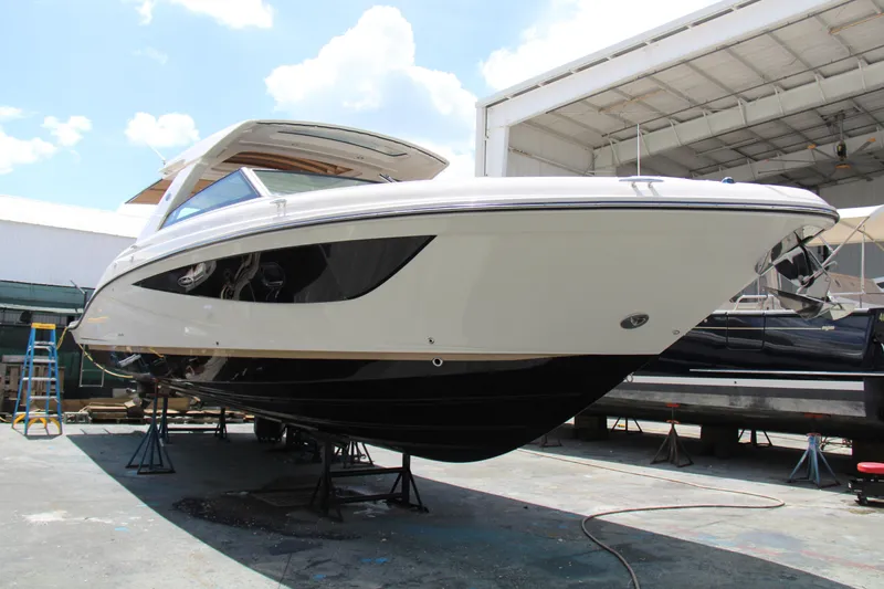 Slide: The Image of 2019 Sea Ray SLX 400 boat on stands in a marina, under a clear sky. - 5