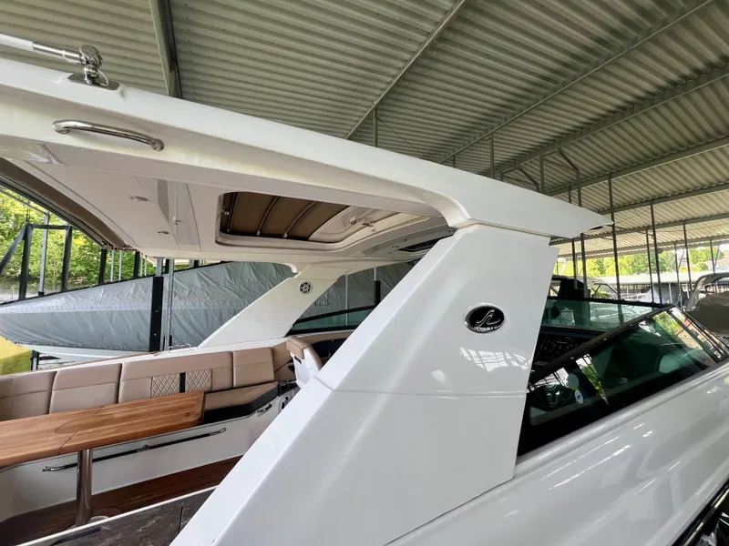 Slide: The Image of 2019 Sea Ray SLX 400 boat with sleek design under a covered dock. - 8