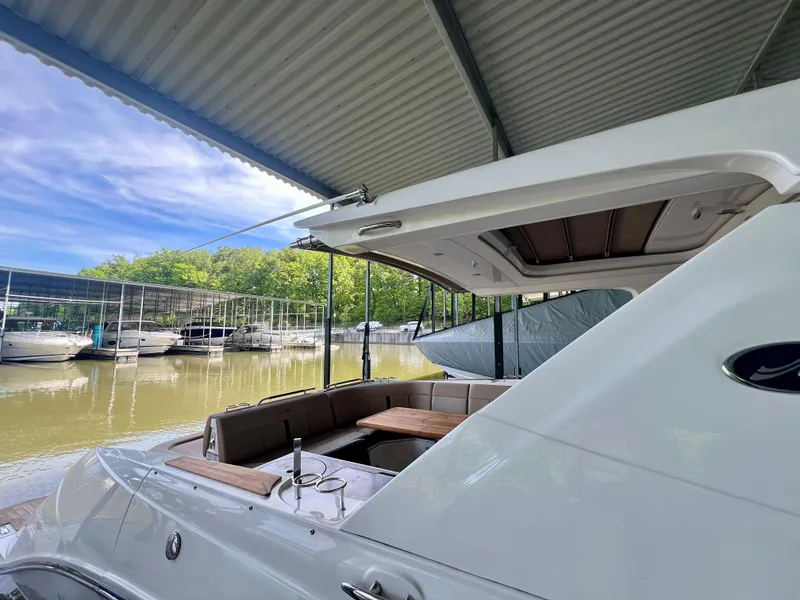 Slide: The Image of 2019 Sea Ray SLX 400 yacht docked under a canopy, featuring a spacious seating area. - 9