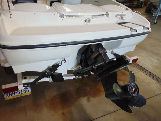 Slide: The Image of 2009 Bayliner 175 boat stern with outboard motor in a garage setting. - 2