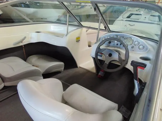 Slide: The Image of 2009 Bayliner 175 boat interior with steering wheel and seating. - 4