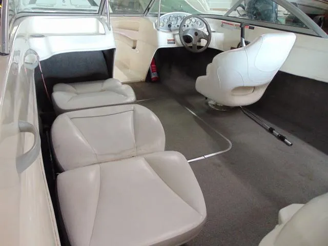 Slide: The Image of 2009 Bayliner 175 boat interior with white seating and steering console. - 9