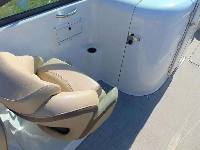 Slide: The Image of 2019 NauticStar 243 DC boat interior with beige seating and storage compartment. - 10