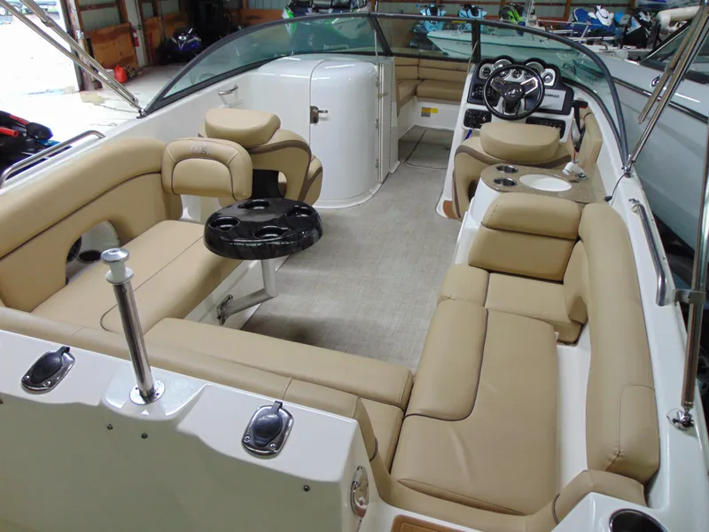 Slide: The Image of 2019 NauticStar 243 DC boat interior with beige seating and steering console. - 11