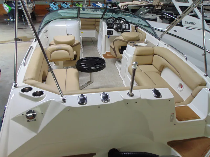 Slide: The Image of 2019 NauticStar 243 DC boat interior with beige seating and steering console. - 12