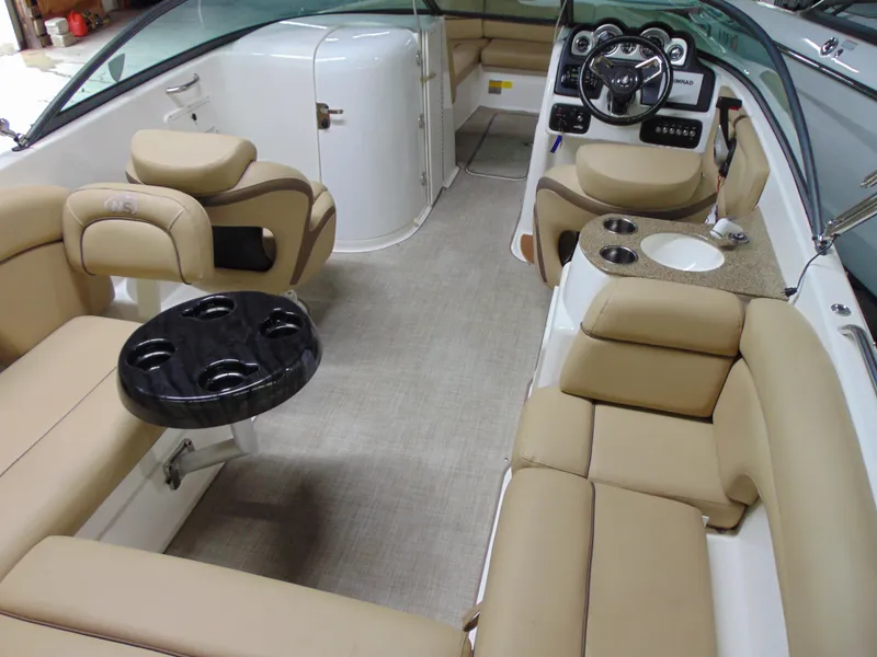 Slide: The Image of 2019 NauticStar 243 DC boat interior with beige seating and modern dashboard. - 13