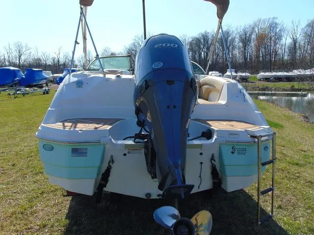 Slide: The Image of 2019 NauticStar 243 DC boat with 200 HP engine, parked on grass near water. - 4