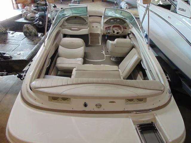 Slide: The Image of 2000 Maxum 1900SR boat interior with beige seating and dashboard, in a showroom. - 4