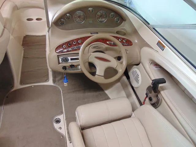 Slide: The Image of 2000 Maxum 1900SR boat interior with beige upholstery and detailed dashboard controls. - 7