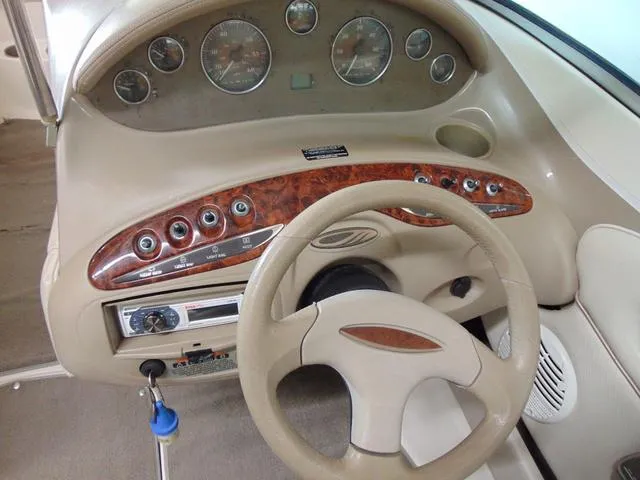 Slide: The Image of Steering wheel and dashboard of a 2000 Maxum 1900SR boat, featuring wood accents and gauges. - 8