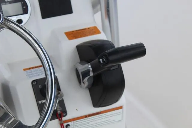 Slide: The Image of Control panel of a 2018 Robalo R180 boat, featuring steering wheel and throttle lever. - 21