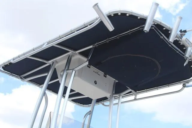 Slide: The Image of 2018 Robalo R180 boat T-top with rod holders against a blue sky. - 26