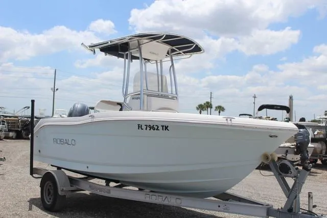 Slide: The Image of 2018 Robalo R180 boat on trailer under cloudy sky. - 3