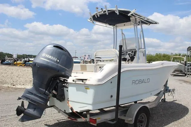 Slide: The Image of 2018 Robalo R180 boat with Yamaha outboard motor on trailer, parked outdoors. - 4