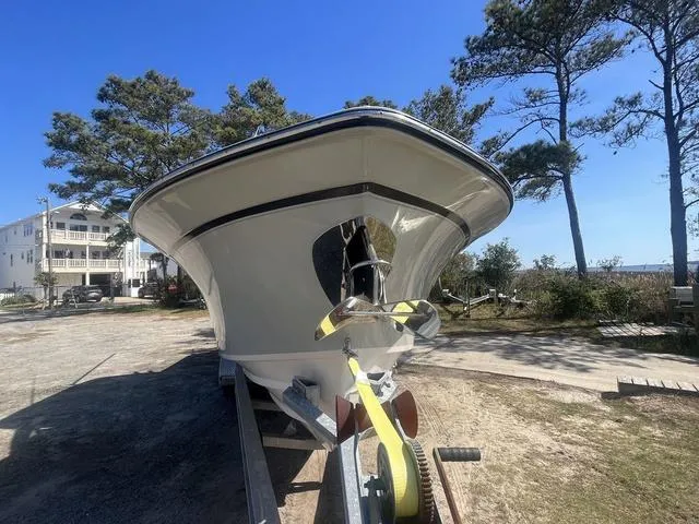 Slide: The Image of 2016 Grady-White Freedom 275 boat on trailer, surrounded by trees and clear sky. - 2