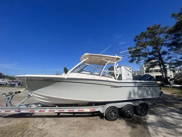 Slide: The Image of 2016 Grady-White Freedom 275 boat on trailer under clear blue sky. - 3
