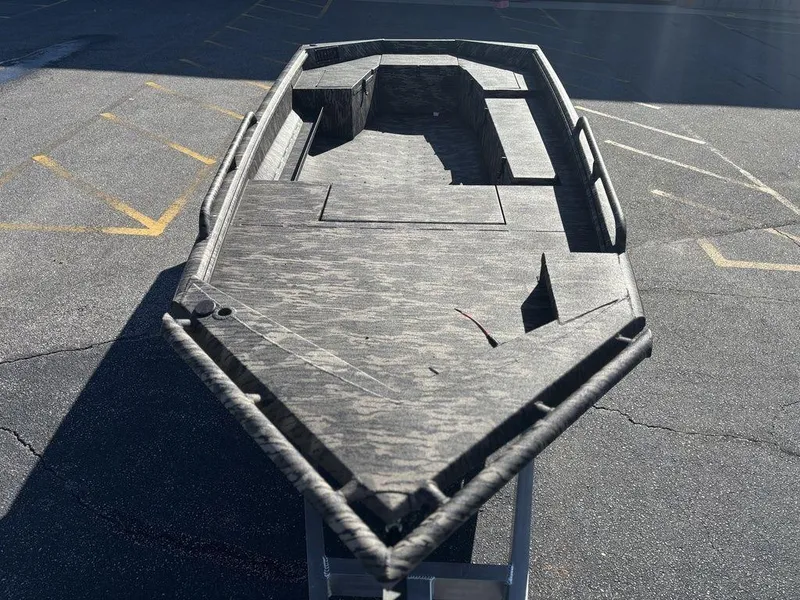 Slide: The Image of 2025 Havoc DBST 1656 boat with a sleek, camo design on a paved surface. - 2