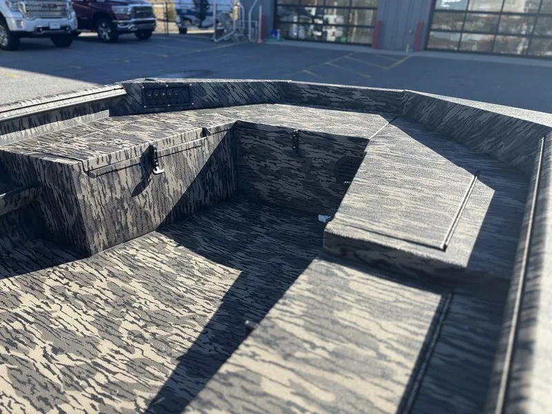 Slide: The Image of 2025 Havoc DBST 1656 boat interior with camouflage design, parked outdoors. - 7