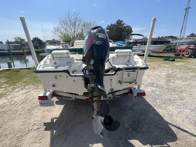 Slide: The Image of 1999 Boston Whaler 160 Dauntless boat with Evinrude motor, parked on a trailer. - 5