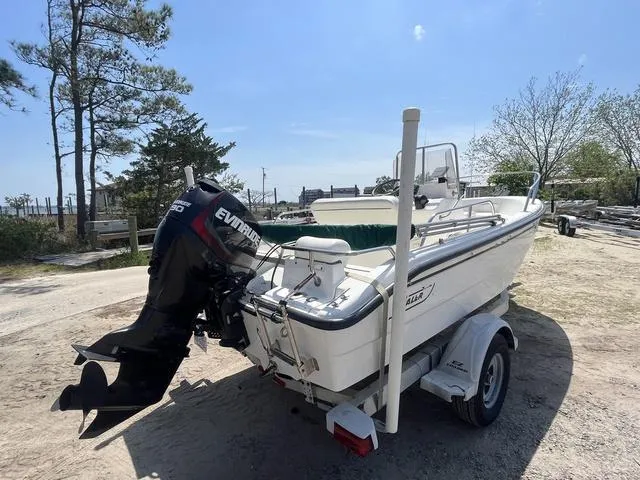 Slide: The Image of 1999 Boston Whaler 160 Dauntless boat on trailer with Evinrude motor, parked outdoors. - 6