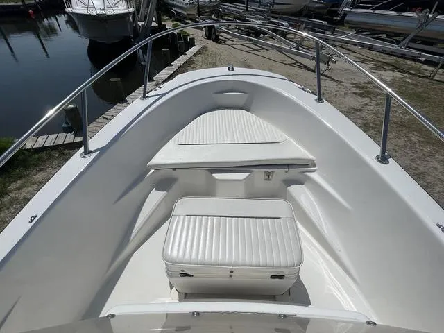 Slide: The Image of 1999 Boston Whaler 160 Dauntless boat interior with white seating and railings. - 8