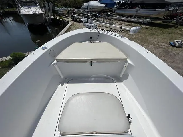 Slide: The Image of 2017 Sportsman 17' Island Reef boat interior with seating and storage, docked near other boats. - 7